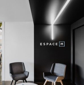 A woman in a white coat smiles warmly, exuding a sense of friendliness and approachability